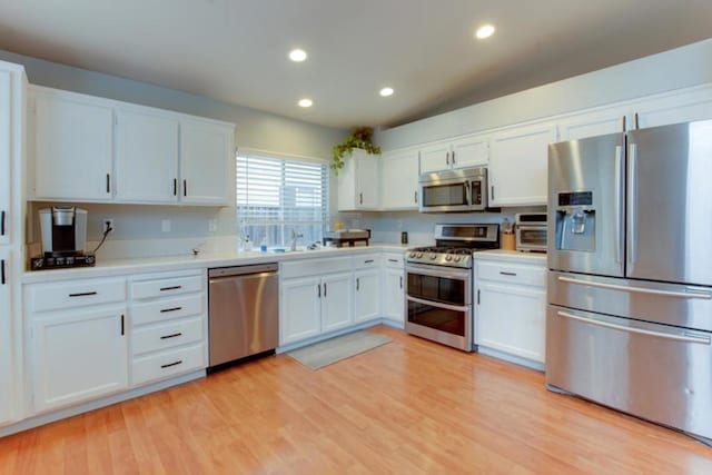 kitchen featuring sink, stainless steel appliances, white cabinets, and light wood-type flooring