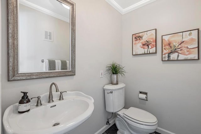 bathroom featuring crown molding, sink, and toilet