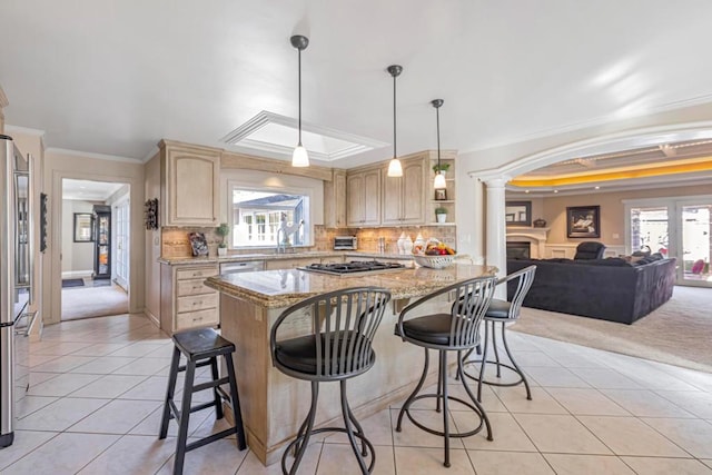 kitchen featuring crown molding, decorative light fixtures, light brown cabinets, a raised ceiling, and decorative columns