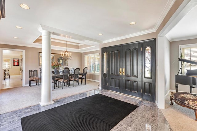 entrance foyer with decorative columns, ornamental molding, and a notable chandelier