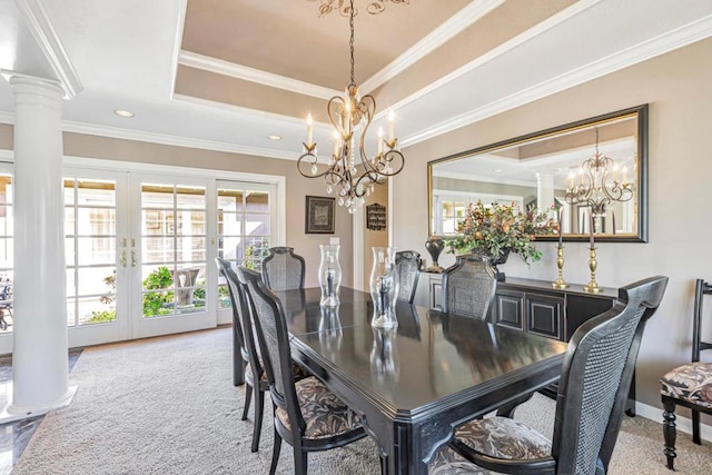 dining space with ornamental molding, a tray ceiling, carpet, and ornate columns