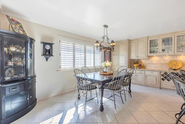 tiled dining area featuring a notable chandelier and ornamental molding