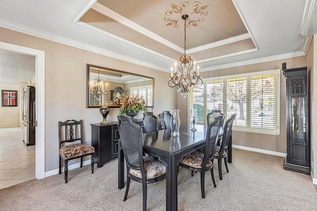 carpeted dining space featuring crown molding, a chandelier, and a tray ceiling