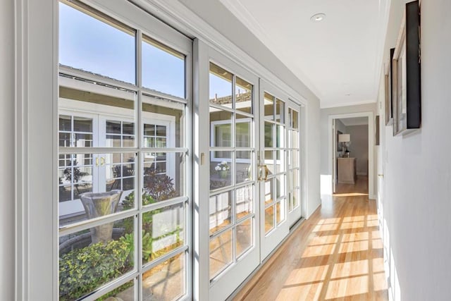 interior space with hardwood / wood-style flooring, crown molding, and french doors