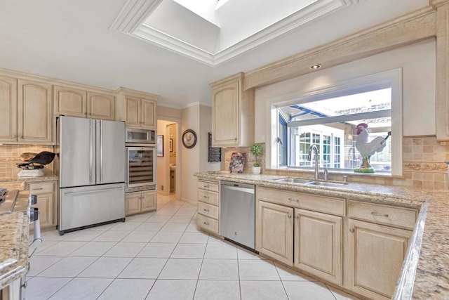 kitchen featuring light tile patterned floors, appliances with stainless steel finishes, sink, and light brown cabinets