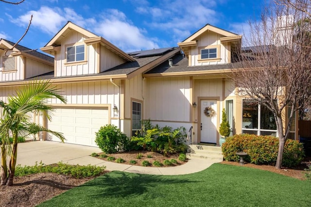 view of front of property featuring a garage, a front yard, and solar panels