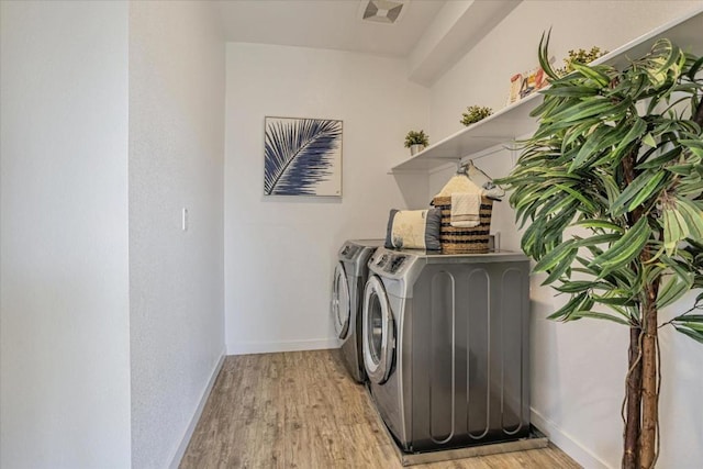 laundry area featuring washer and dryer and light wood-type flooring