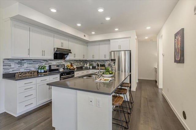 kitchen featuring stainless steel appliances, sink, a center island with sink, and white cabinets