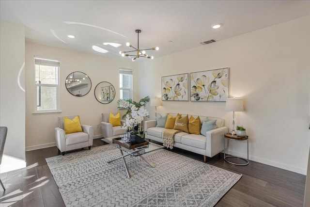 living room with dark wood-type flooring, a chandelier, and a wealth of natural light