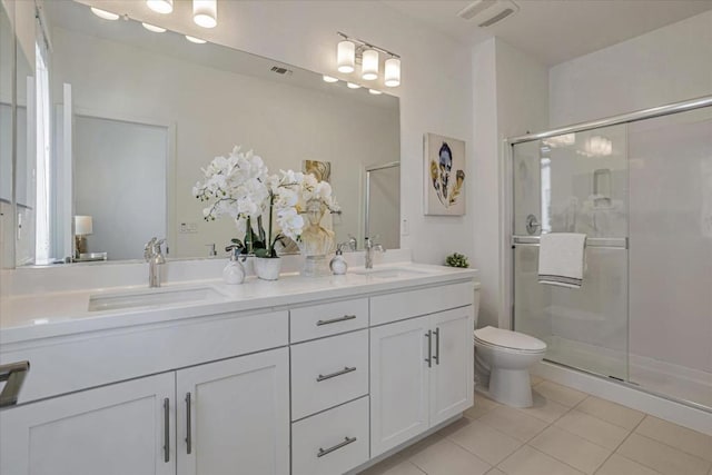 bathroom featuring walk in shower, vanity, toilet, and tile patterned flooring