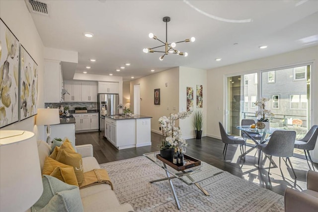 living room featuring dark hardwood / wood-style floors, sink, and a notable chandelier