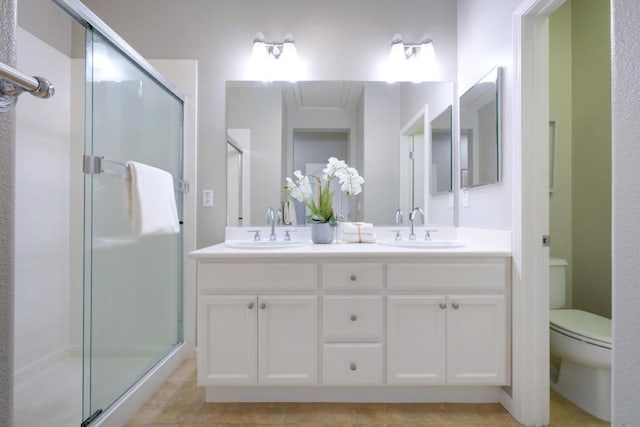 bathroom featuring vanity, an enclosed shower, and toilet