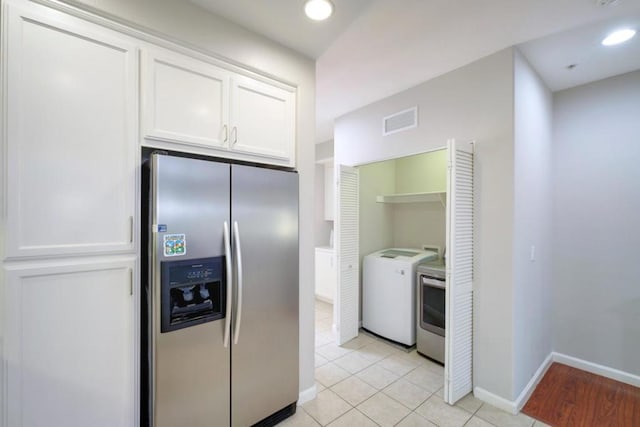 kitchen featuring stainless steel refrigerator with ice dispenser, white cabinetry, independent washer and dryer, and light tile patterned floors