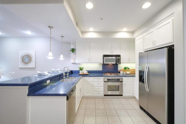 kitchen with appliances with stainless steel finishes, kitchen peninsula, sink, and white cabinets