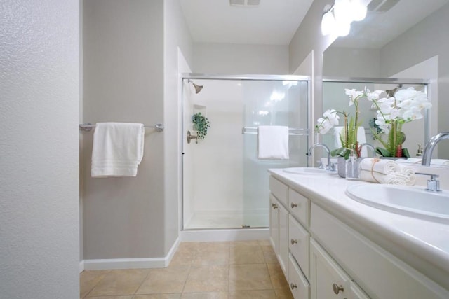 bathroom featuring a shower with door, vanity, and tile patterned floors