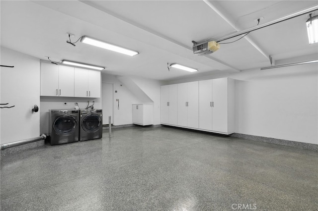 garage with separate washer and dryer and a garage door opener