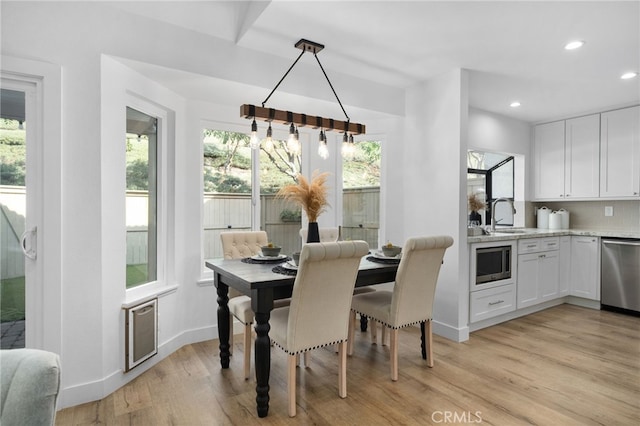 dining area with sink and light hardwood / wood-style floors