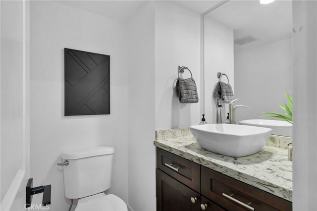 bathroom featuring vanity and toilet