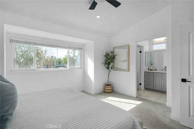 carpeted bedroom featuring connected bathroom, vaulted ceiling, and ceiling fan