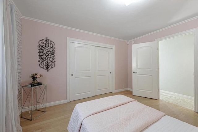 bedroom featuring a closet, ornamental molding, and light hardwood / wood-style floors