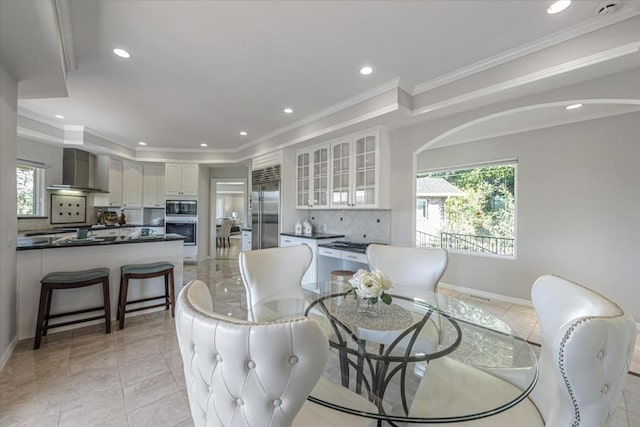 dining area featuring ornamental molding and a healthy amount of sunlight