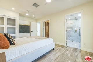 bedroom with ceiling fan and ensuite bath