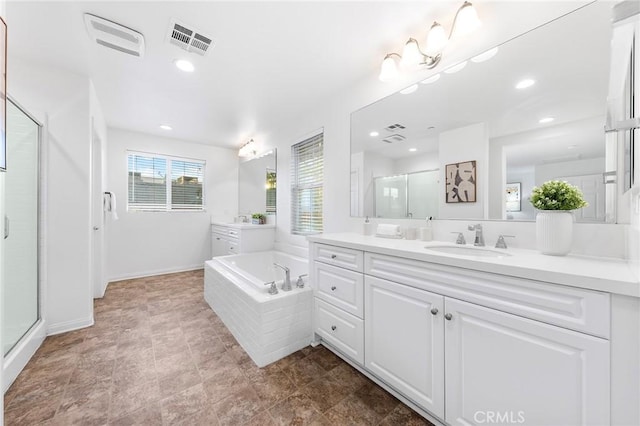 bathroom with vanity and shower with separate bathtub