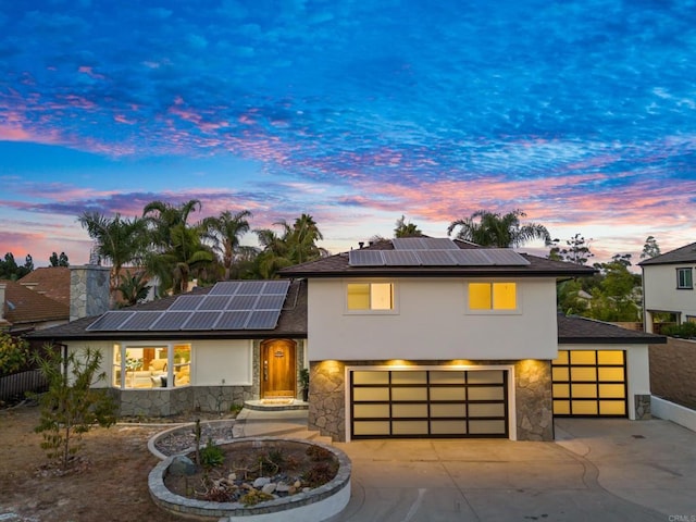 view of front of home featuring a garage and solar panels