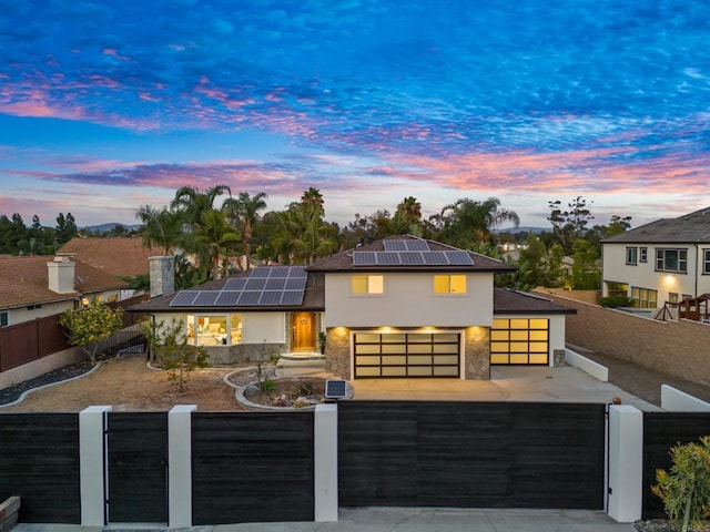 view of front facade featuring a garage and solar panels