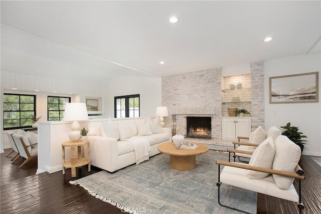 living room with a brick fireplace and dark hardwood / wood-style floors