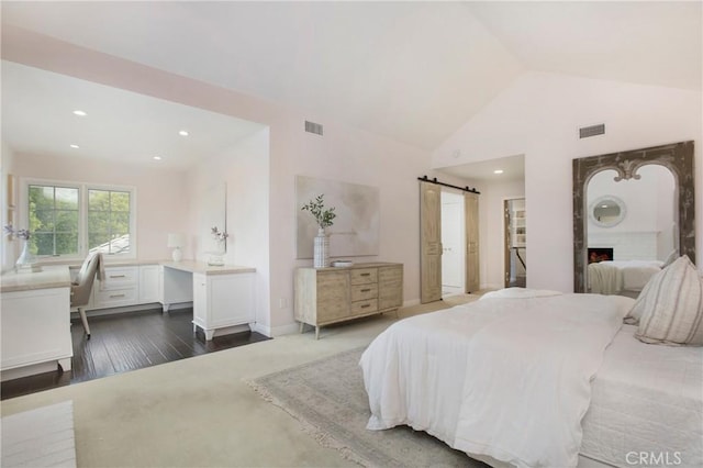 bedroom featuring a brick fireplace, dark wood-type flooring, high vaulted ceiling, and a barn door