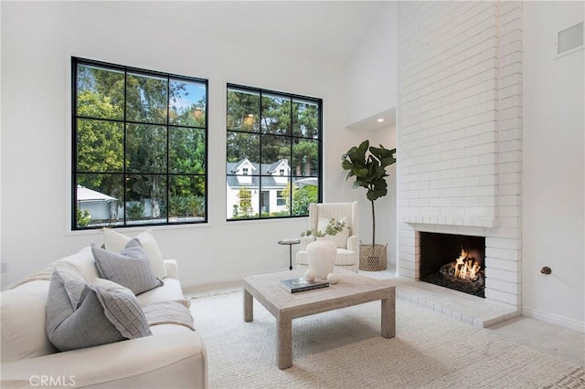 living room featuring a brick fireplace and a towering ceiling