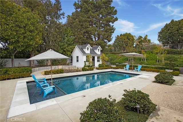 view of swimming pool featuring a patio and an outdoor structure