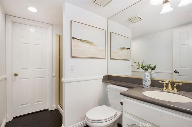 bathroom featuring vanity, toilet, a shower with shower door, and hardwood / wood-style floors