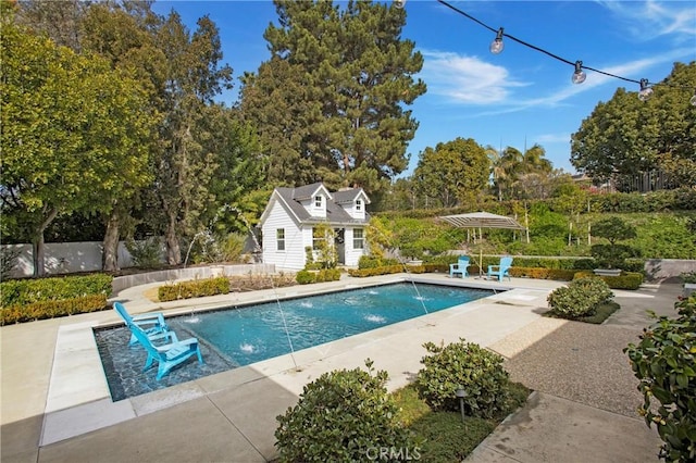 view of swimming pool with pool water feature, a patio, and an outbuilding