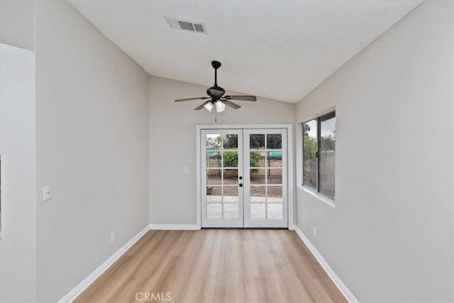 unfurnished room with french doors, ceiling fan, vaulted ceiling, and light wood-type flooring