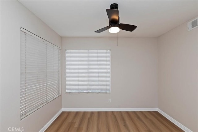 empty room with hardwood / wood-style flooring and ceiling fan