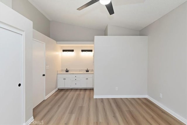 interior space featuring ensuite bathroom, lofted ceiling, sink, and ceiling fan