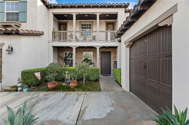 property entrance featuring a garage and a balcony