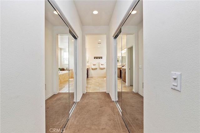 corridor featuring light colored carpet