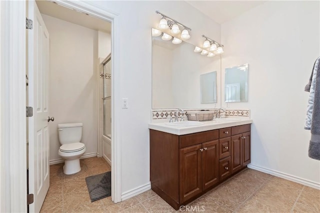 full bathroom featuring vanity, bath / shower combo with glass door, backsplash, and toilet