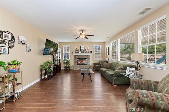 living room featuring ceiling fan, a fireplace, and dark hardwood / wood-style floors