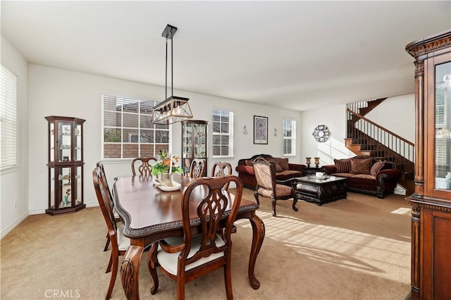 dining area featuring light carpet