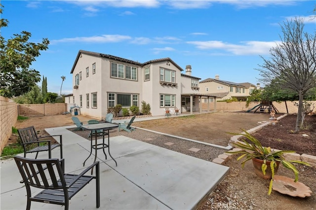 rear view of house featuring a pergola, a playground, and a patio area