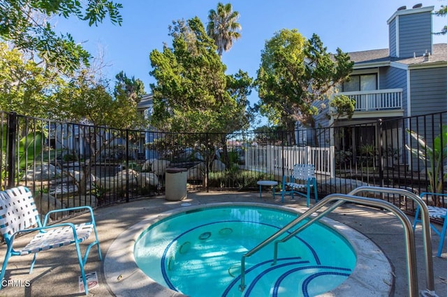 view of pool with a hot tub