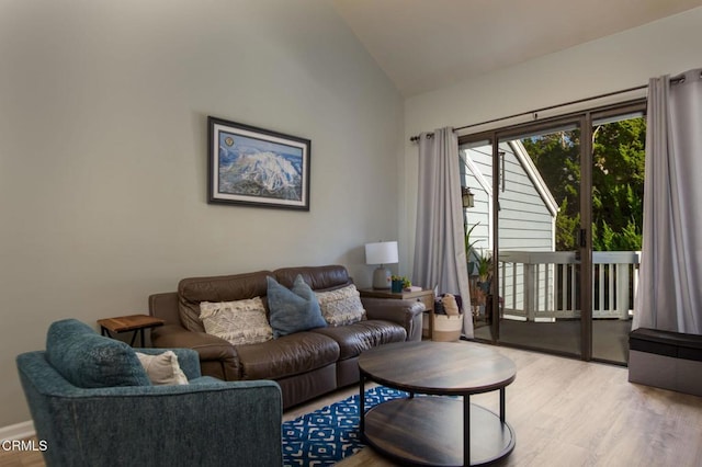 living room featuring lofted ceiling and light hardwood / wood-style floors