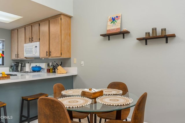 kitchen featuring range, a kitchen breakfast bar, and kitchen peninsula