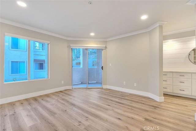 spare room with crown molding and light wood-type flooring