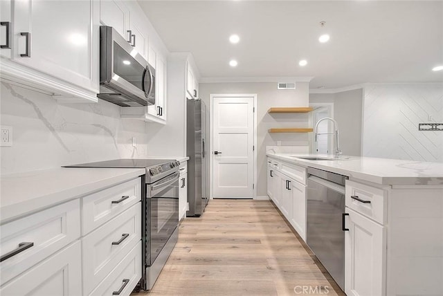 kitchen featuring light wood-type flooring, stainless steel appliances, sink, and white cabinets