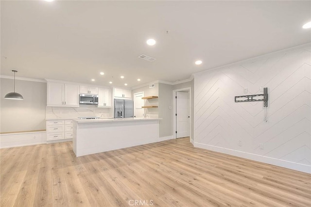 kitchen featuring decorative light fixtures, light hardwood / wood-style flooring, ornamental molding, appliances with stainless steel finishes, and white cabinets